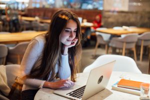 A woman working on a laptop in a cafe