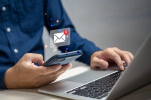 Image of a businessman holding a hand touchscreen smartphone, checking email icons online, sending mail to partners and customers via a virtual interface, representing technology concepts